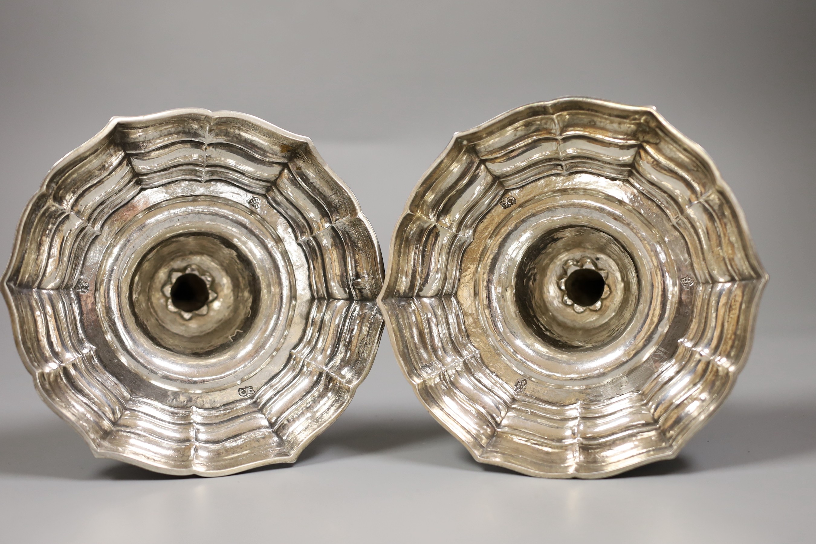 A pair of French Louis XVI cast white metal candlesticks and sconces, with waisted knopped stems, on shaped circular bases, maker, Jean Schoutheer, Dunkirk mark, circa 1775, height 26.2cm, 36oz.
